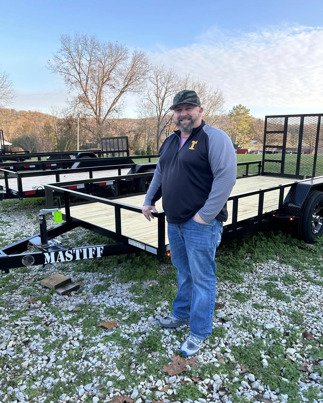 Man standing next to a black Mastiff utility trailer.